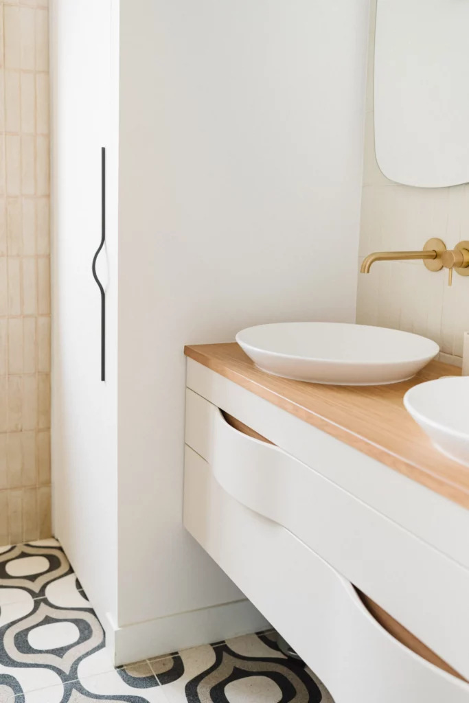 Salle de bain double vasques, salle de bain entièrement rénovée avec murs blancs, agencements modernes et installation. refaire sa salle de bain par un professionnel
