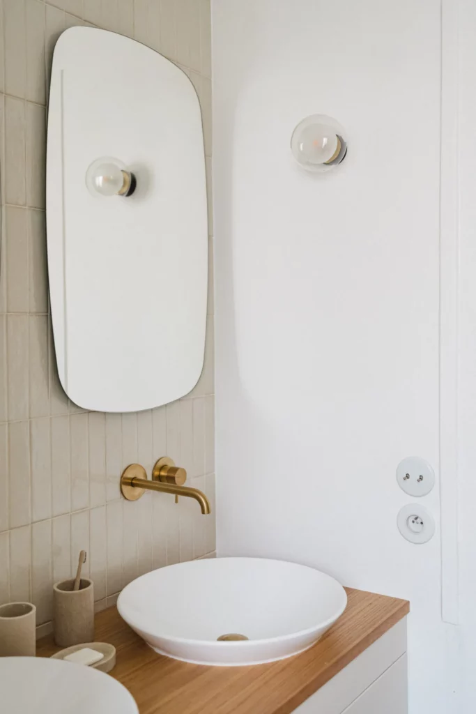 Salle de bain entièrement rénovée avec murs blancs, agencements modernes et installation. refaire sa salle de bain par un professionnel