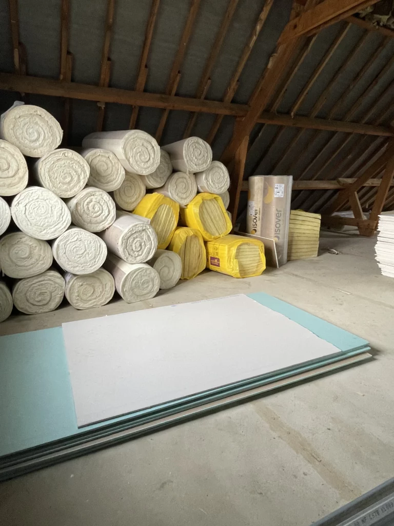 Rouleaux de laine de verre dans un grenier avant installation pour isolation phonique
