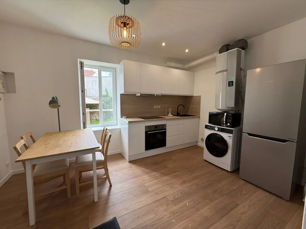 Appartement T2 entièrement rénové à Lorient, avec cuisine équipée moderne, salle de bain avec douche et pièce de vie optimisée comprenant coin nuit et espace salon, idéal pour location.
