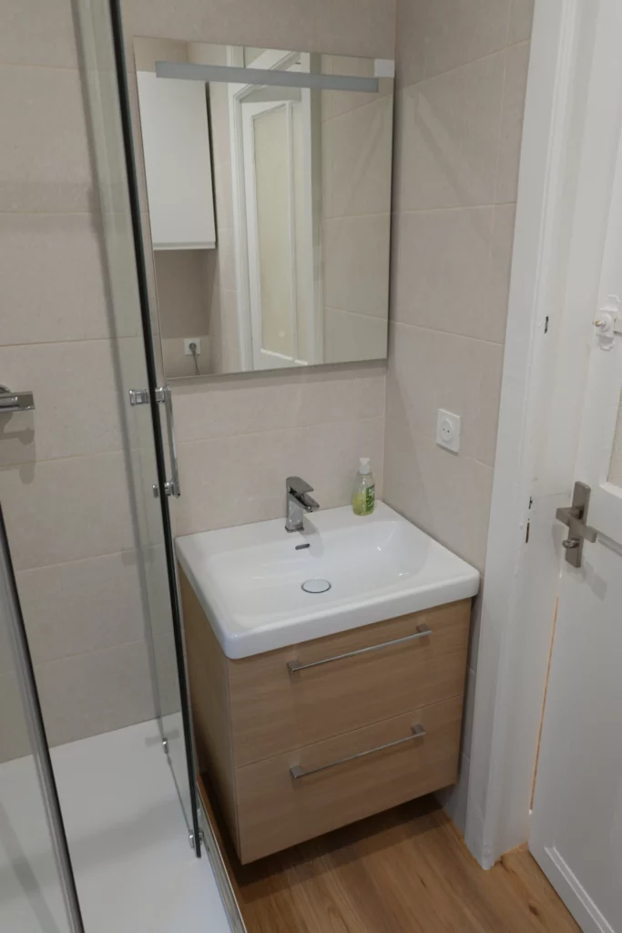 Lavabo moderne avec meuble vasque dans une salle de bain rénovée.