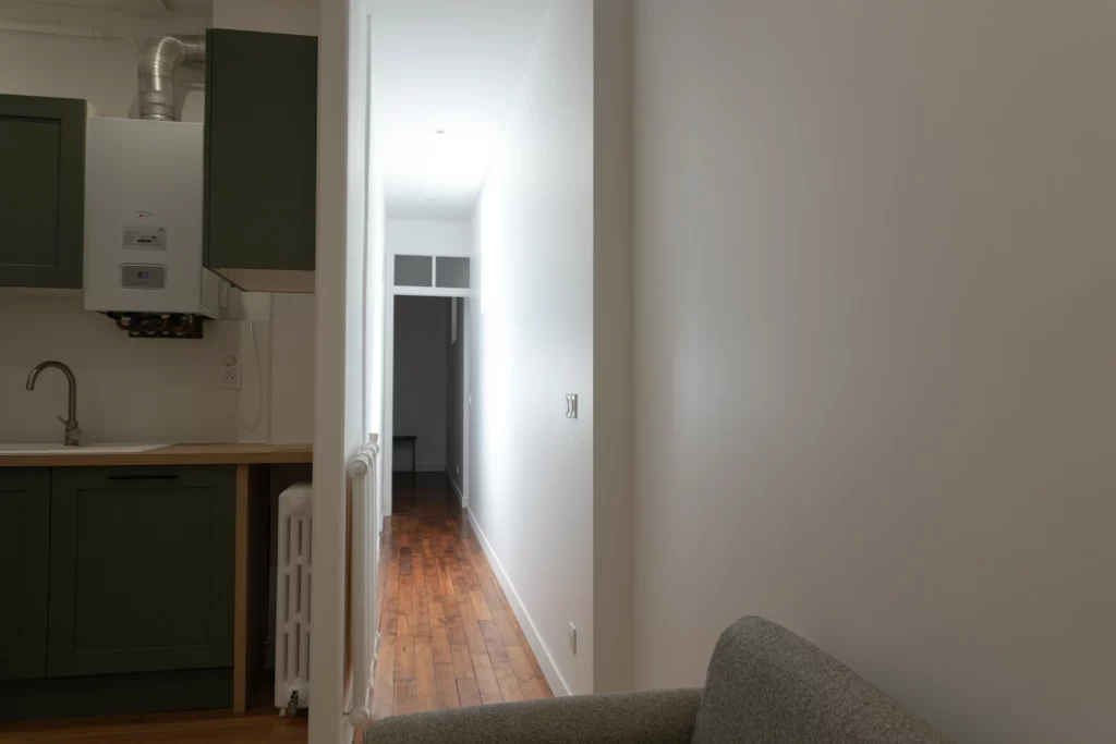 Couloir d'un appartement T2 rénové dans le centre de Rennes avec parquet vitrifié.